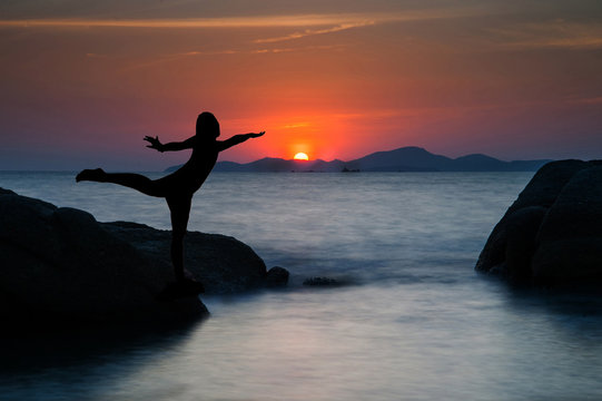 Silhouette of a beautiful yoga woman at sunset