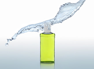 The green moisturizing shampoo stands on the water background with splash