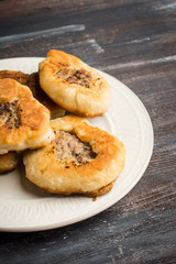 Homemade meat pies on the wooden background