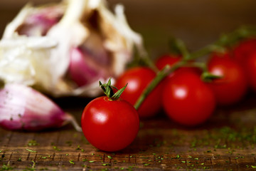 cherry tomatoes and garlics on a wooden table