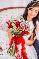 Portrait of beautiful girl with bouquet of flowers.Attractive girl with flowers,sitting ear the red,clean lake.Nice girl with unusual,creative,.Lovely,pretty girl hold in hands flowers.