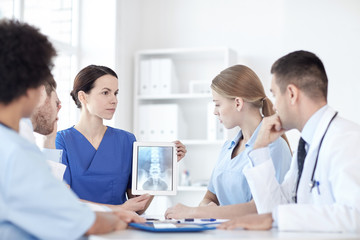 group of doctors with x-ray on tablet pc at clinic