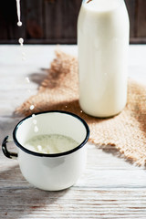 
milk in the bottle , jug and cup on the wooden background