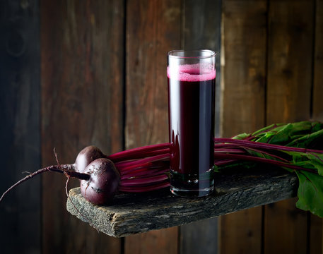 beet juice in a glass on a wooden background
