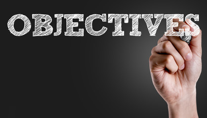 Hand writing the text: Objectives