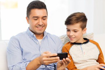 happy father and son with smartphone at home