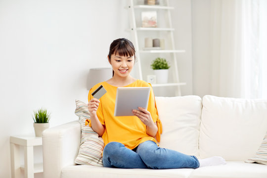 happy asian woman with tablet pc and credit card