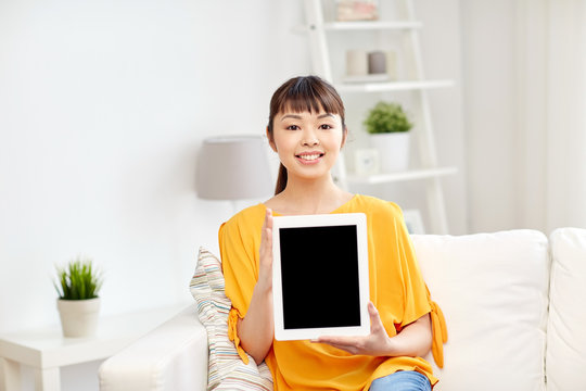 happy young asian woman with tablet pc at home