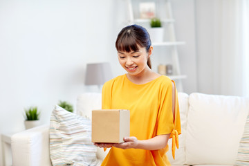 happy asian young woman with parcel box at home