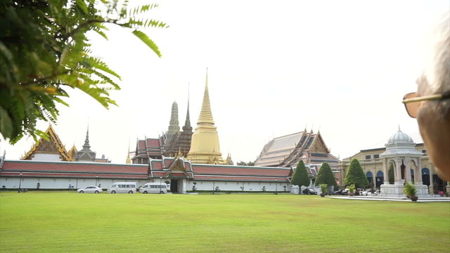 Asian senior man visiting Wat Phra Kaew, Temple of the Emerald Buddha Landmark of Bangkok,Thailand