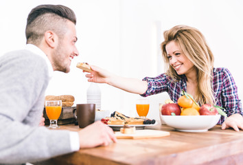 Young happy couple having breakfast in the morning