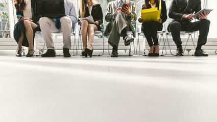 Row of business people waiting for an interview