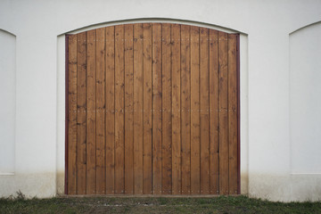 Big wooden barn gate. Monumental farm door, two timber leaf, closed brown gateway with planks and...