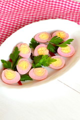 Pickled peeled hard-boiled quail eggs, stained pink by grated beet 