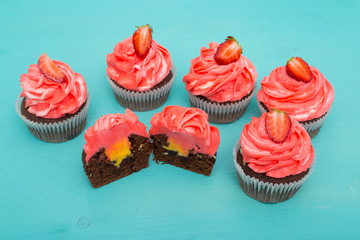 Multicolored red-yellow chocolate cupcakes with strawberry