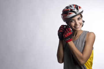 Ragazza sorridente vestita da Ciclista si sgancia il casco