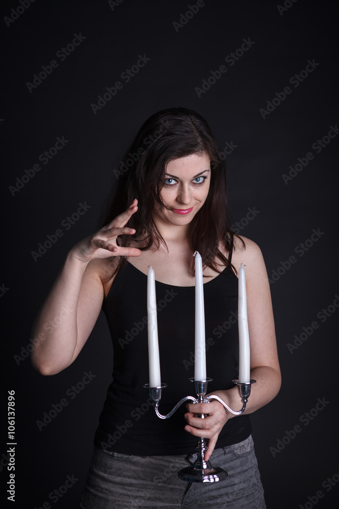 Wall mural beautiful woman on a dark background with the candlestick in han