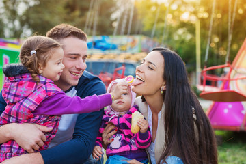 Family with little girls enjoying time at fun fair