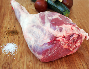 Fresh and raw meat. Leg of lamb on wood background