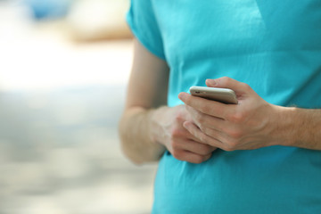 Man holding smart mobile phone outdoors