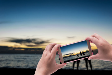 Hand with smart phone shooting photograph