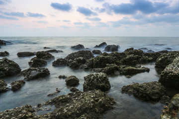 Fototapeta na wymiar Coastal twilight scene, Long Exposure of rocks and waves at suns