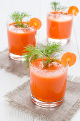 Three glasses of carrot juice, on linen napkin