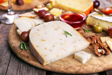 Different kinds of cheese on wooden background