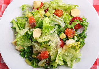 Tasty salmon salad on light wooden background