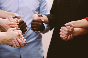 White caucasian and black afro american hands holding together, friendship concept