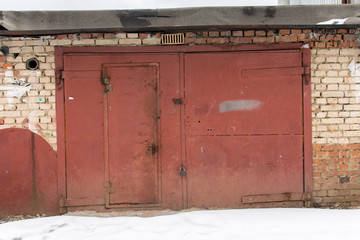 metal door of garage with lock. brick background