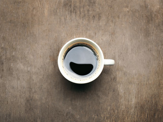 Cup of coffee on wooden table, top view