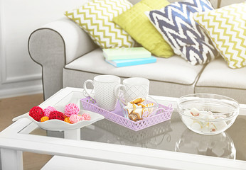 Low table with sweets and two cups in living room