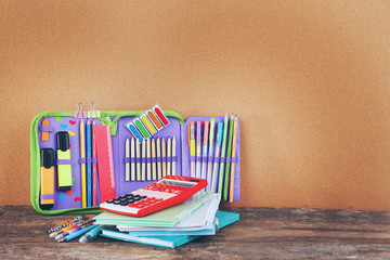 Pencil case with various stationery on old  wooden table