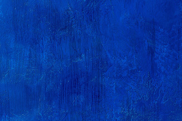 Old scratched and chapped painted royal blue wall. Abstract textured colored background, empty template