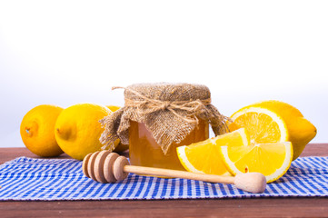 Honey comb, fresh lemon and ginger on a wooden table, white background
