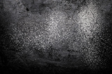 Flour spilling on black background. Toned