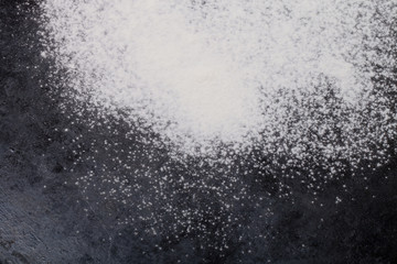 Fototapeta na wymiar Flour spilling on black background