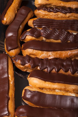 Set of homemade chocolate eclairs for tasty background. Selectiv