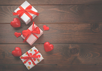 Gift boxes and decorative hearts on wooden background