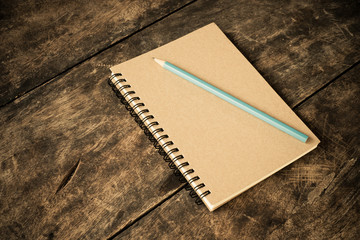 still life with notebook and pencil on table - vintage filter