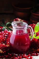 Pitcher with fresh pomegranate juice, selective focus