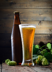 beer, bottle and hop on a wooden background
