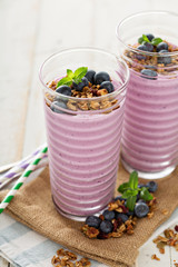 Blueberry smoothie with granola in tall glasses