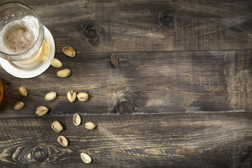 Glass of beer and pistachios background. Top view