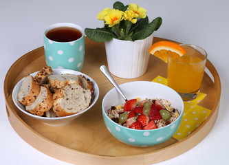 Healthy breakfast: cereals with fresh fruits, wholemeal bread, tea and fresh orange juice