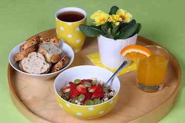 Healthy breakfast: cereals with fresh fruits, wholemeal bread, tea and fresh orange juice