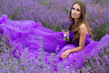 Fashion girl is sitting in lavender field 