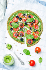 vegan broccoli zucchini pizza crust with spinach pesto, tomatoes