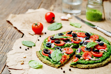 vegan broccoli zucchini pizza crust with spinach pesto, tomatoes